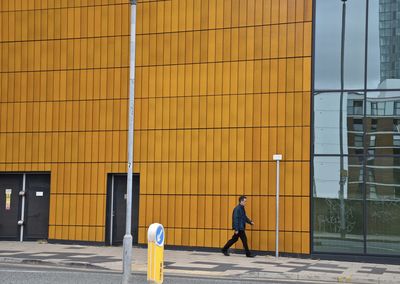 Man walking on yellow building
