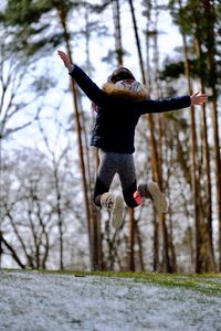 Full length of man jumping in forest