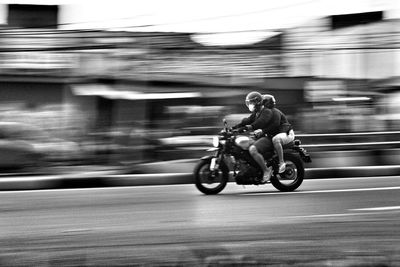 Man riding motorcycle on street in city