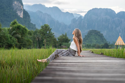 Rear view of woman walking on boardwalk