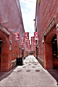 Red road amidst buildings against sky