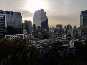 Buildings in city against sky during sunset