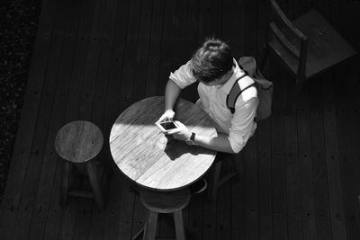 High angle view of man using mobile phone while sitting at outdoor cafe