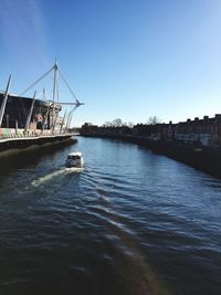 Boat sailing on canal against sky