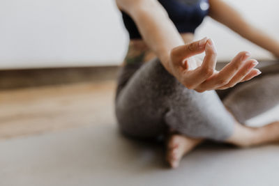 Low section of woman meditating at home