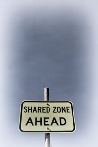 Low angle view of road sign against sky