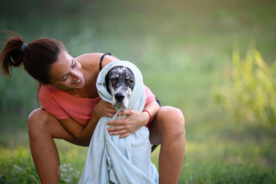 Side view of young woman holding dog