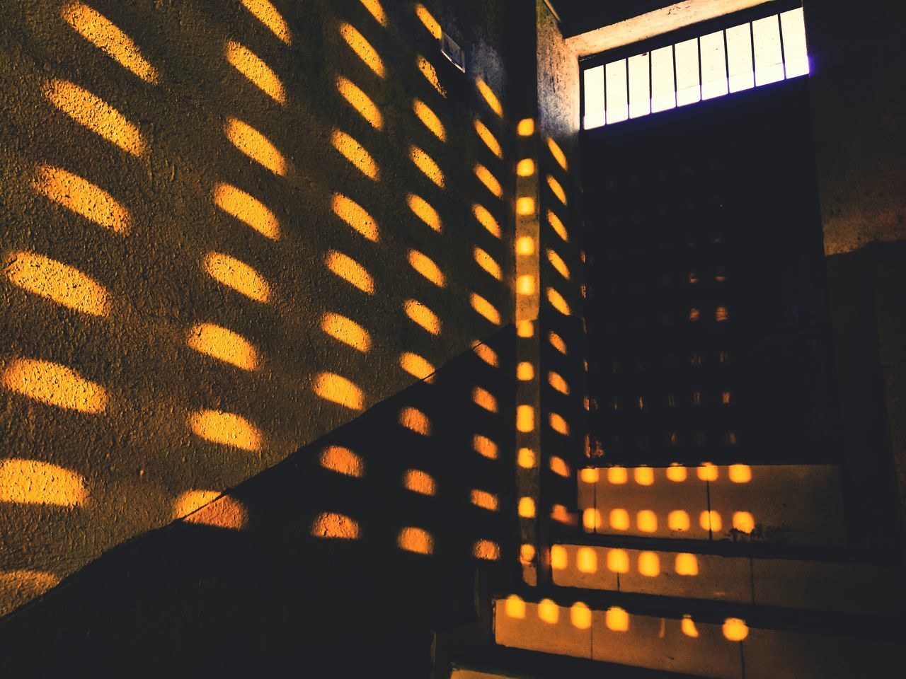 LOW ANGLE VIEW OF ILLUMINATED ORANGE BUILDING