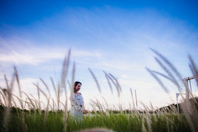 Woman standing on field against sky