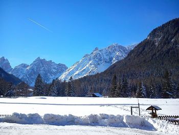 Scenic view of snowcapped mountains against blue sky