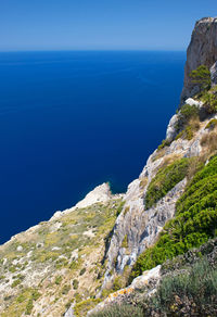 Scenic view of sea and mountains against clear blue sky