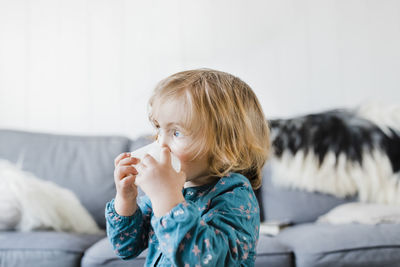 Cute girl looking away in living room at home