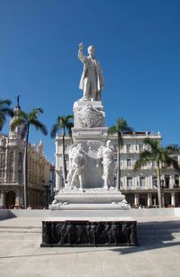 Statue in front of building against clear sky