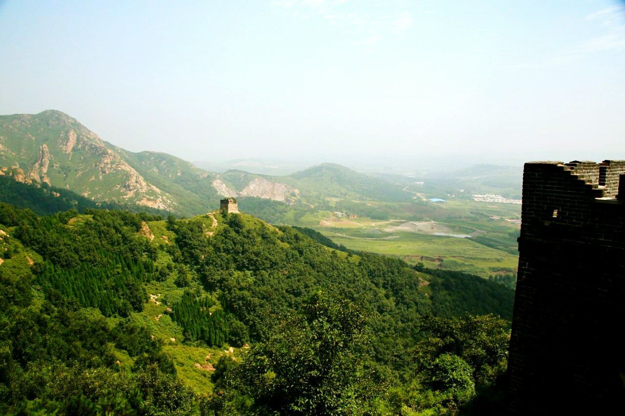 mountain, mountain range, tranquil scene, tranquility, scenics, landscape, tree, beauty in nature, nature, green color, fog, non-urban scene, growth, sky, idyllic, built structure, hill, high angle view, building exterior