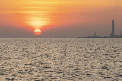 Scenic view of sea against orange sky