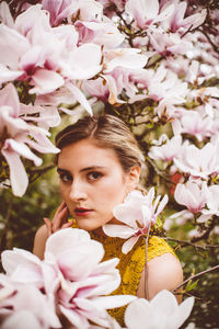 Portrait of young woman amidst pink flowers