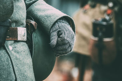 Close-up of man holding metal while standing outdoors