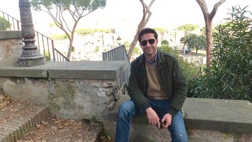 Portrait of a young man standing by railing