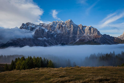 Clouds and fog at dawn from which the wonderful peaks of the dolomites of sesto spring up, italy