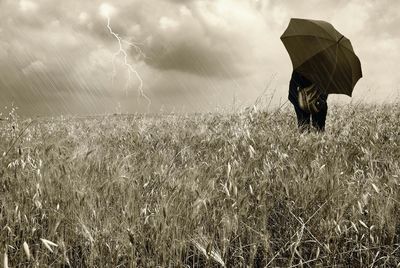 Scenic view of grassy field against cloudy sky