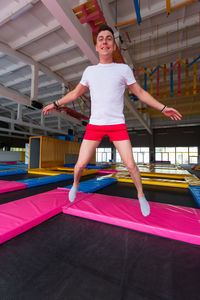Full length of a girl jumping against built structure