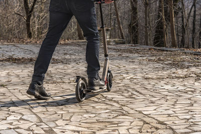 Low section of man riding bicycle on road