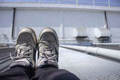 Low section of person wearing shoes on bridge