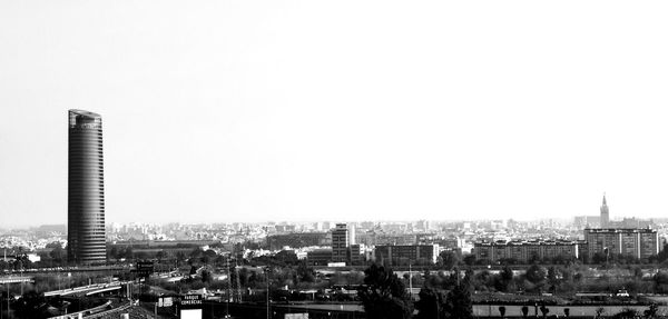 Aerial view of buildings in city against clear sky