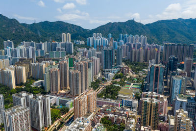 Aerial view of buildings in city against sky