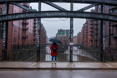 Rear view of man walking on bridge