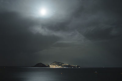 Scenic view of illuminated sea against sky at night