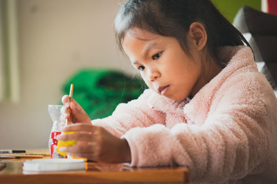 Cute girl making decoration on table