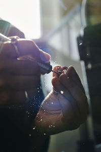 Hands of craftswoman shaping ring with grinder in workshop