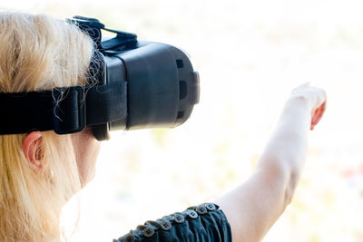 Cropped image of senior woman gesturing while using virtual reality simulator