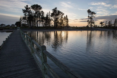 Pier on lake at sunset