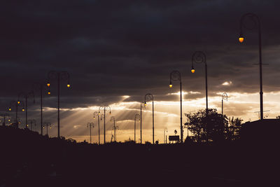 Silhouette of street lights at dusk