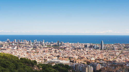 High angle view of townscape by sea against sky