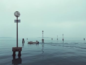 Scenic view of the venetian lagoon in winter against sky with fog and mysterious island 