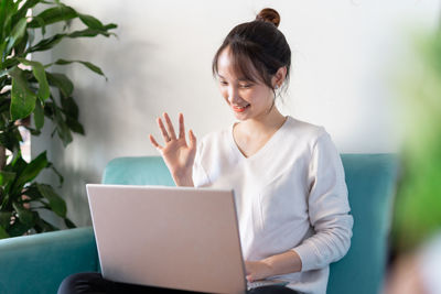 Midsection of woman using laptop at home