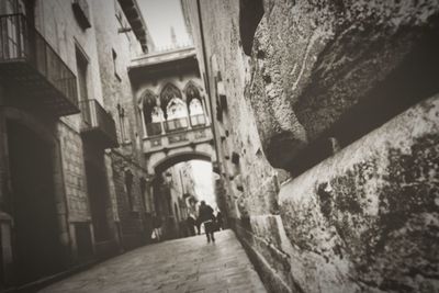 People walking in alley amidst buildings in city