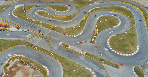 Aerial top view of the go-kart track from the drone. kart racers drive on the open track.