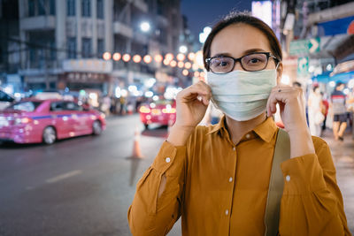 Portrait of woman standing on street in city