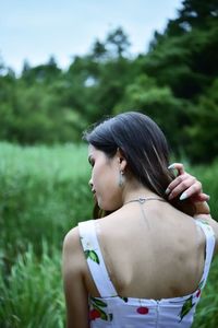 Young woman looking away while standing on land