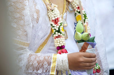 Midsection of bride wearing floral garland