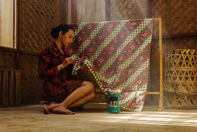 Portrait of young woman sitting on floor 