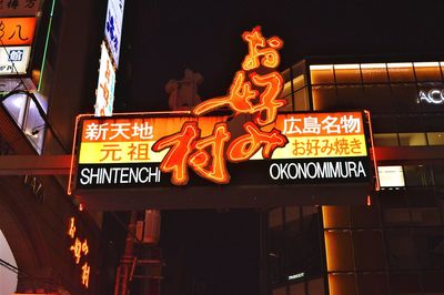 Low angle view of illuminated information sign at night