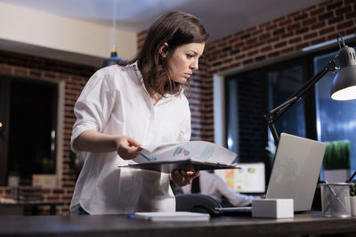 Busy businesswoman reviewing chart at office