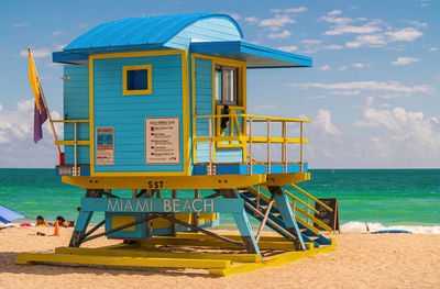 Lifeguard hut on beach against sky