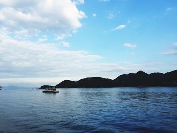 View of calm sea against mountain range