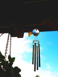 Low angle view of bird hanging against sky